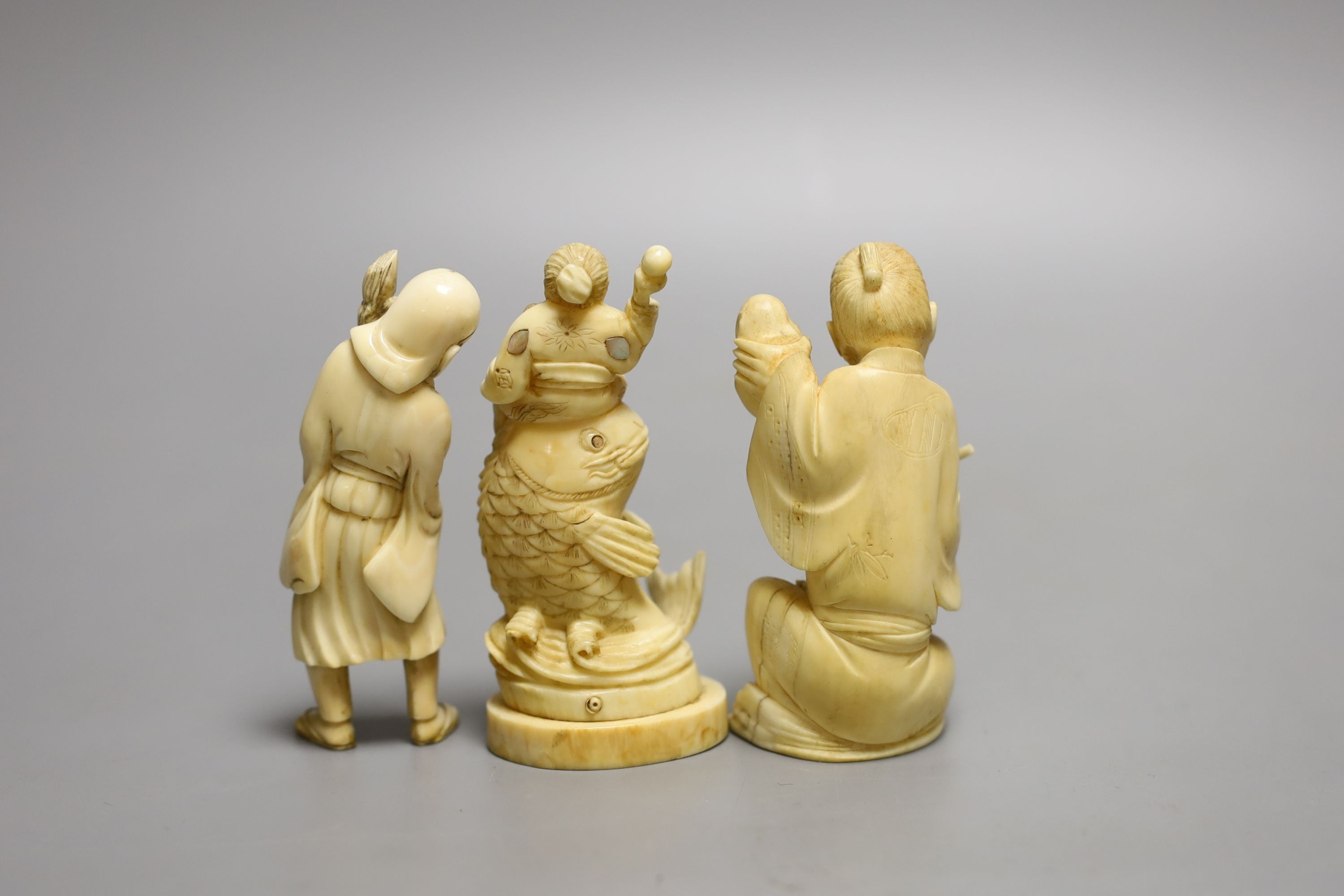 Three Japanese ivory okimono, of a doll maker, a street seller and Kinko seated on a carp, Meiji period - tallest 9.5cm